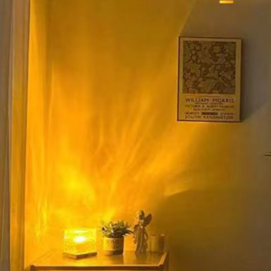 Clear rippled cube atmosphere lamp on a gold tone base projecting moving water light