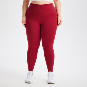 Deep red high waist leggings worn with white sneakers, front view on a light studio background