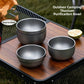 Three grey frosted stainless steel double wall bowls stacked on an outdoor table