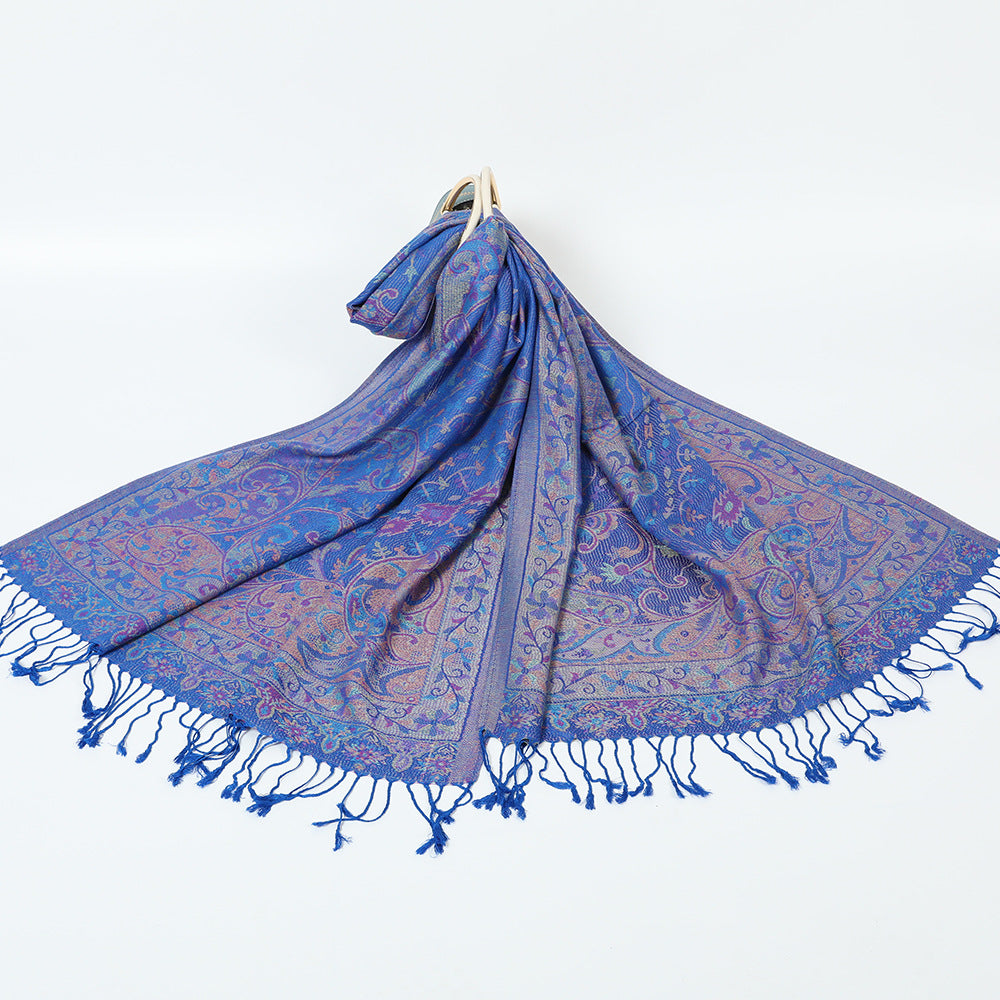 Royal blue paisley jacquard scarf spread on a white background with twisted blue tassel fringe