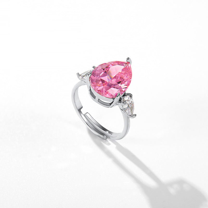 Pear cut pink stone with clear pear accents on an adjustable open shank, white background