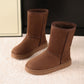 Dark brown suede pull on snow boots pair, side view on a warm studio backdrop