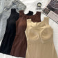 Nude seamless tank top turned to show the built-in fixed chest pads, with black and brown tops behind it