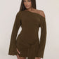 Woman in an olive brown long bell sleeve mini dress with a slanted shoulder neckline and a knot at the hip