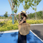 Woven straw tote styled in a bright modern interior with linen and warm tones