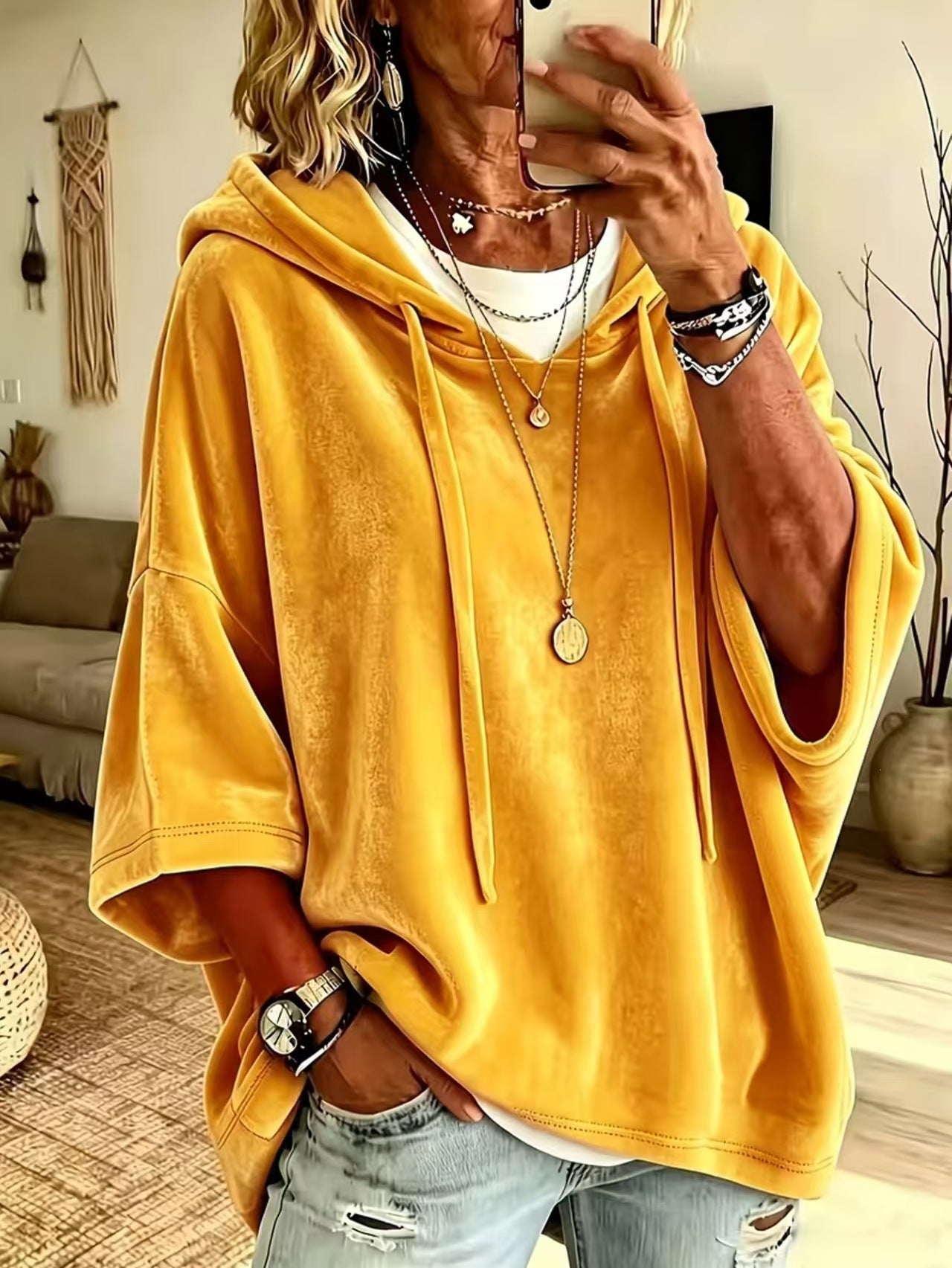 Loose womens hooded top with a drawstring hood shown on a model indoors
