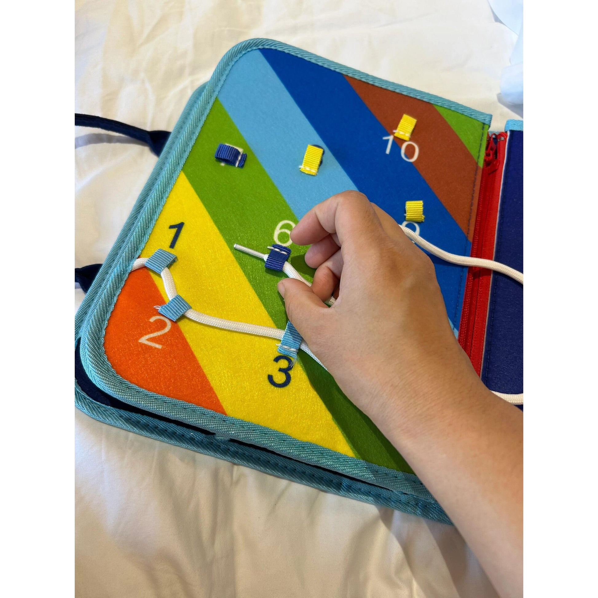 Baby holding the open cloth activity book during play