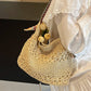 Beige straw shoulder tote with tulips and colorful woven strap on the shoulder