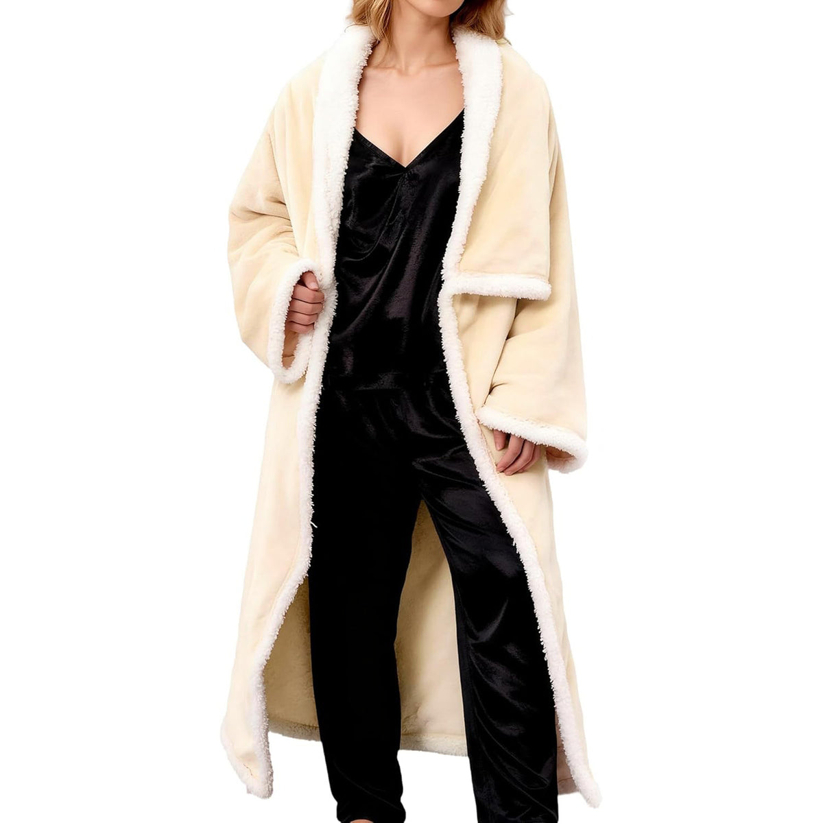 Woman wearing the beige wearable blanket with sleeves and a white lamb fleece collar over dark pajamas
