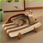 Cat lying on a cream and brown striped corrugated paper lounger with a brown headboard and angled legs