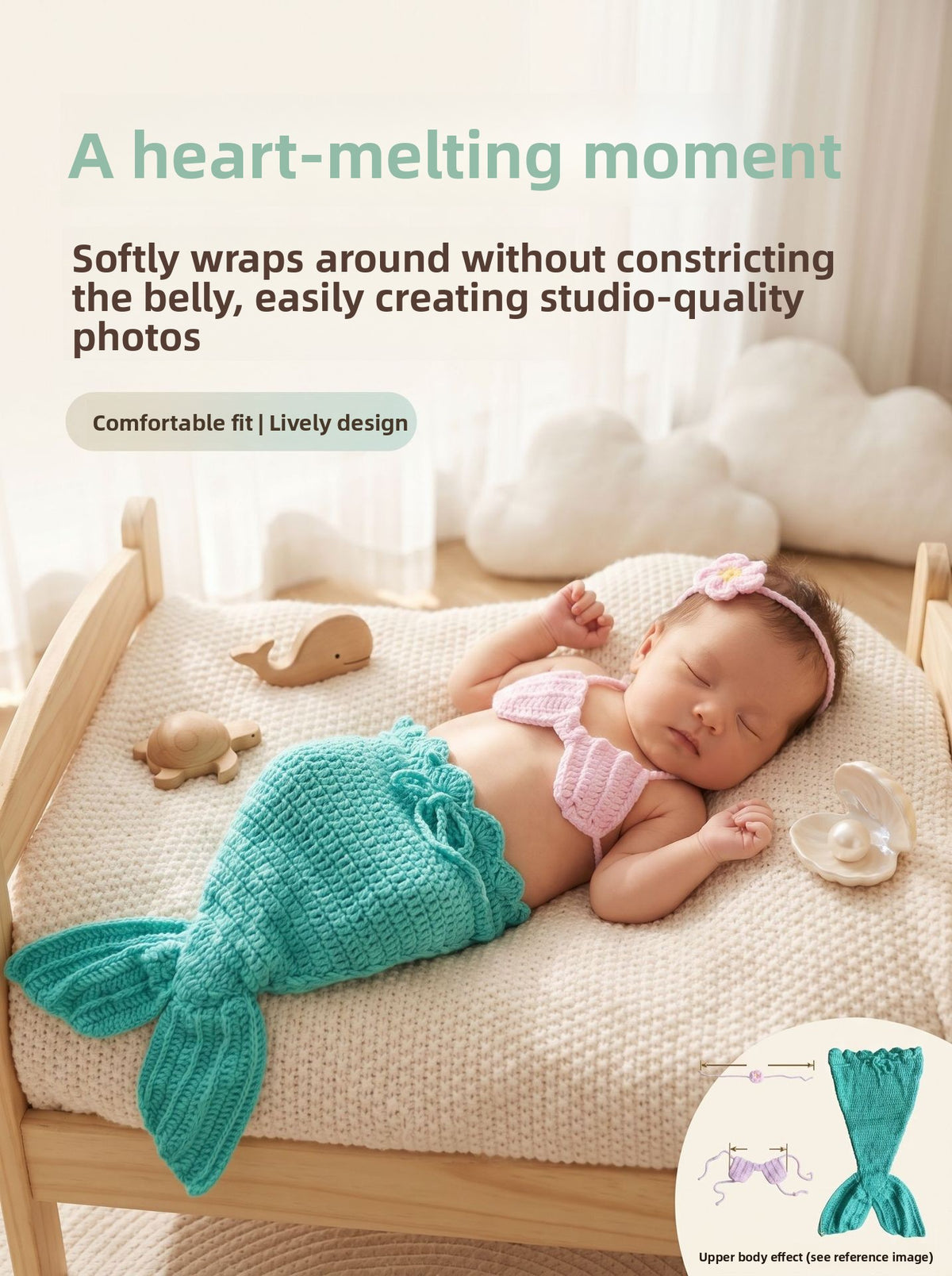 Newborn wearing the teal crochet mermaid tail, pink shell top and flower headband, posed on a small prop bed
