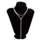 Gold tone layered snake chain lariat necklace displayed on a black bust stand