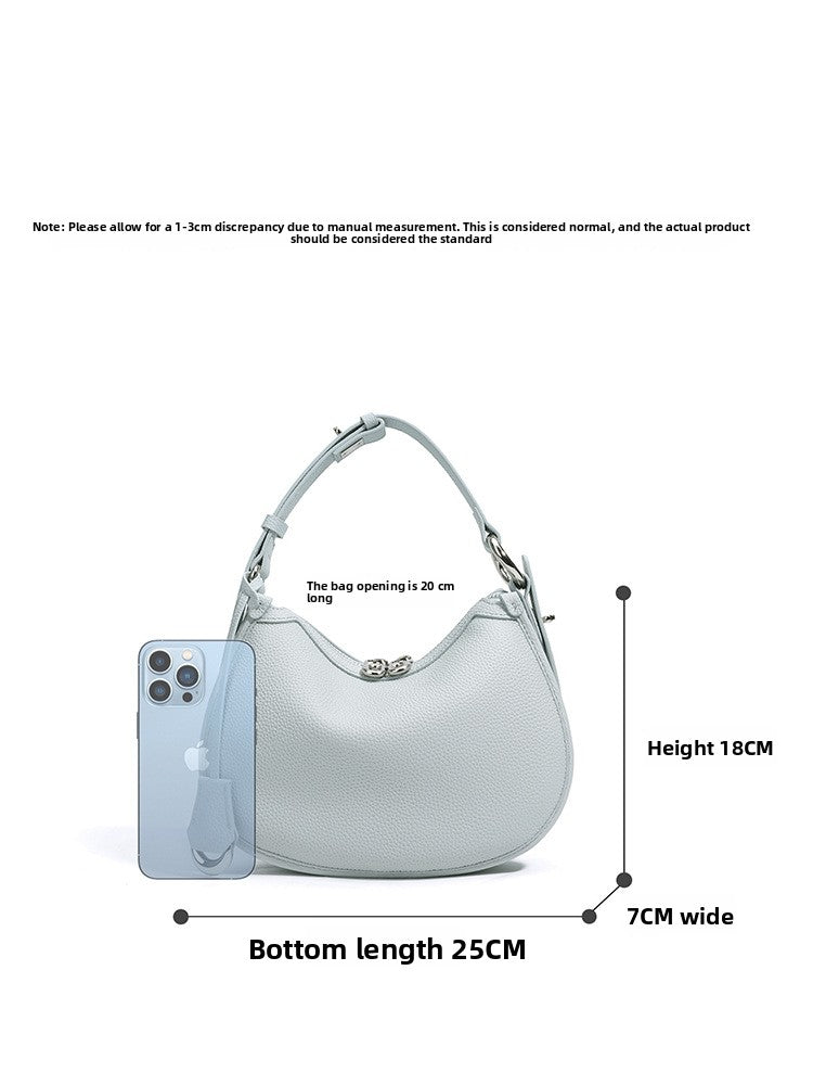 Crescent leather bag with size lines: 25 cm base, 18 cm height, 7 cm width and a phone for scale