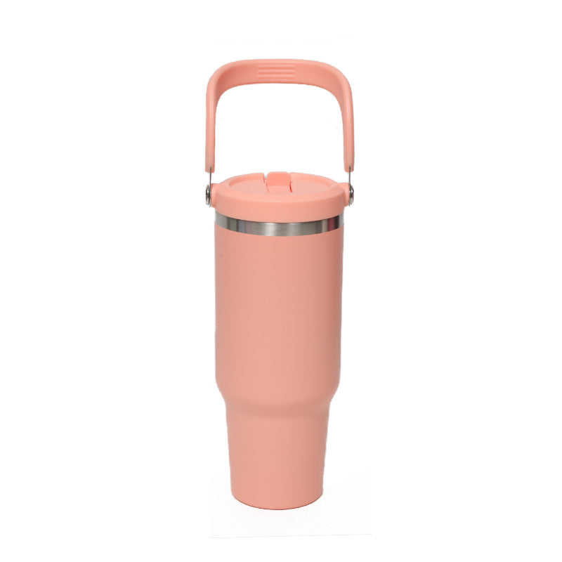 Coral insulated tumbler with a large top handle and a stainless steel ring below the lid on a white background