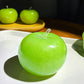 Green apple squishy on a white dish under warm light, icy granular texture through the gel