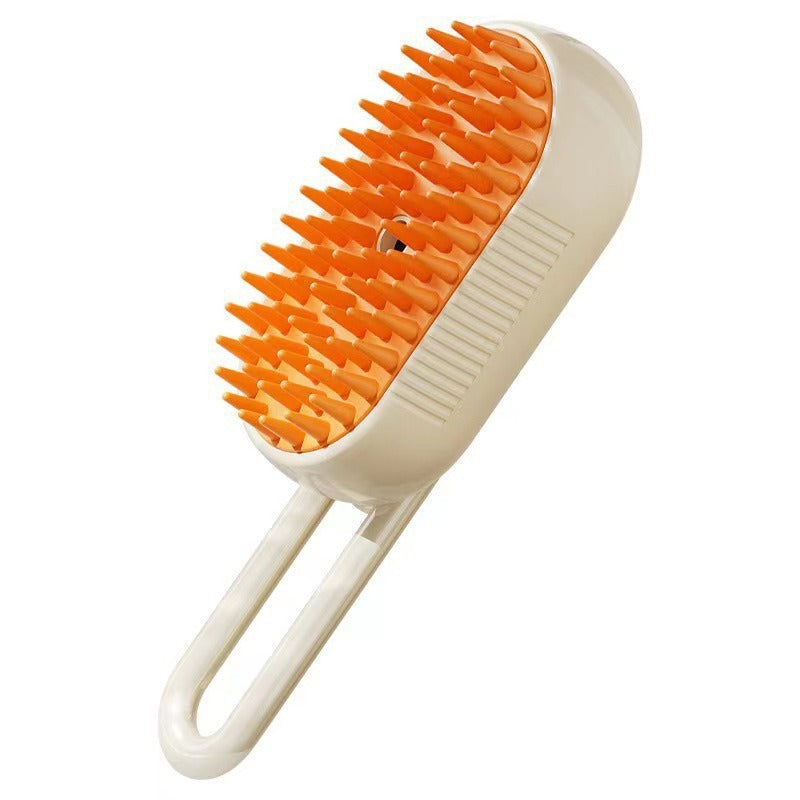 Cream pet spray brush with orange rubber bristles, center nozzle and loop handle on a white background