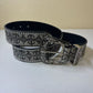 Close view of the studded edges and embossed scroll pattern on the grey western belt