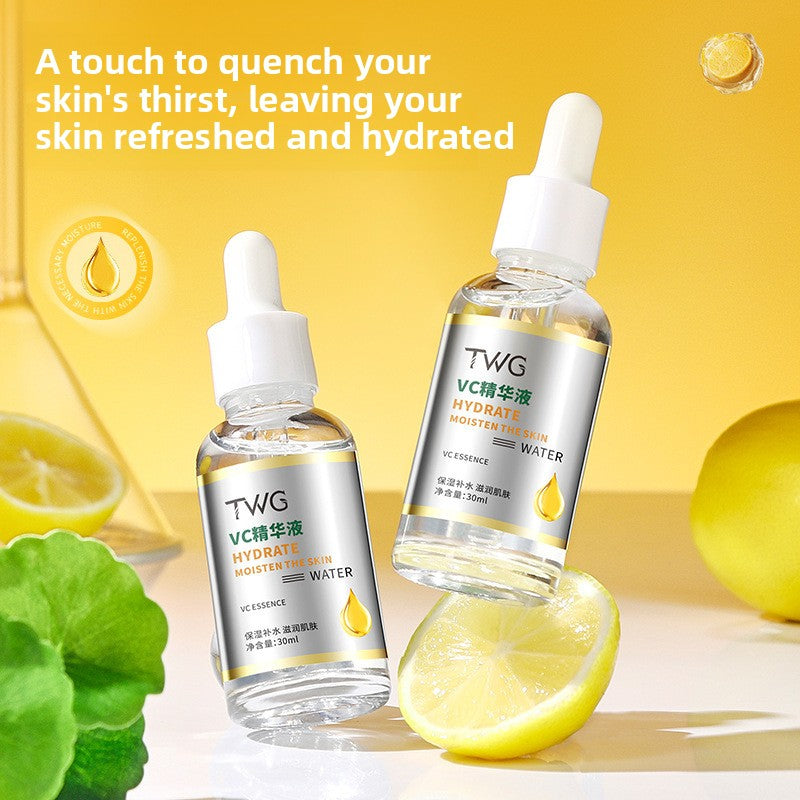 Two TWG VC essence bottles resting beside a lemon slice and green centella leaf