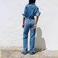 Back view of washed denim jumpsuit with back patch pockets and straight full-length legs on a model