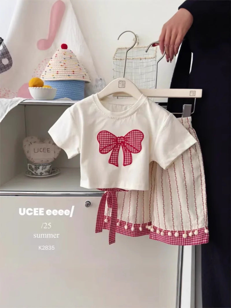 Young girl wearing the bow print short sleeve set during play at home