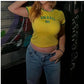 Woman wearing yellow Brasil fitted crop tee with green ringer trim