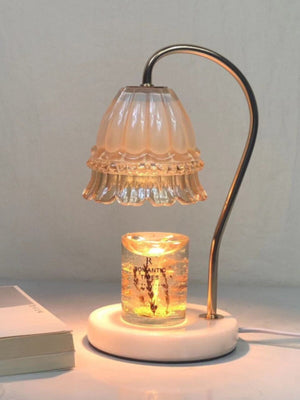 Aromatherapy candle warmer lamp lit on a bedside table