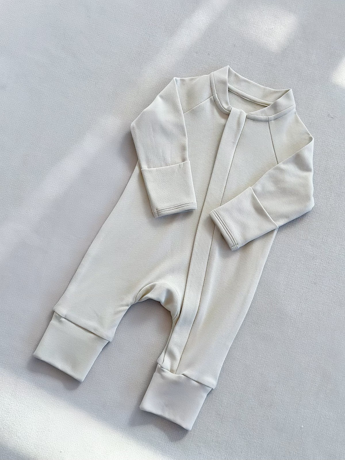 Lime White zip front baby romper laid flat on a gray floor, image of the 90 cm, 18 to 24 months size option