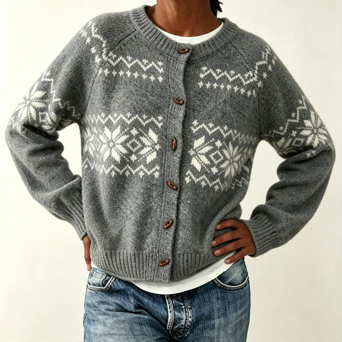Gray knit cardigan with off-white snowflake band and loose fit, shown with hands on hips