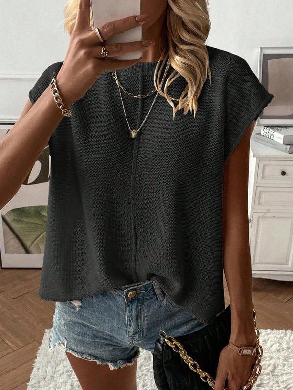Relaxed fine knit top with a round neck and cap sleeves styled with denim shorts