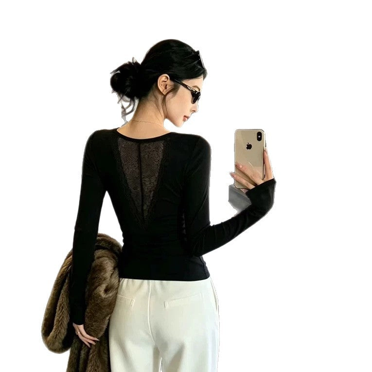 Black long sleeve top seen from the back on a white background with a V shaped sheer lace panel