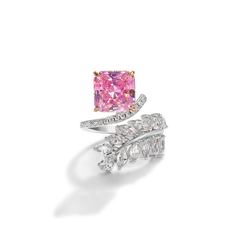 Cushion cut pink stone on a bypass band with a spray of clear marquise stones curling opposite