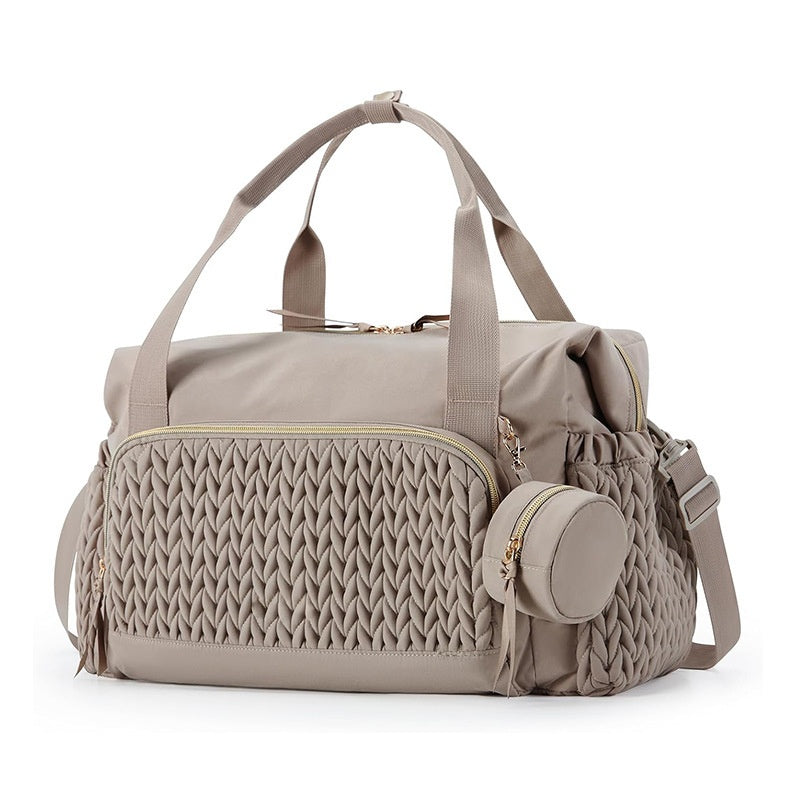 Taupe brown nylon diaper bag tote with braided quilt front pocket, twin handles and a round pacifier pouch