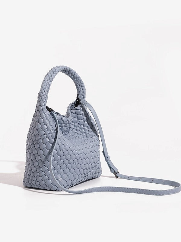 Grey woven bucket bag with the slim adjustable crossbody strap clipped on and extended to the side