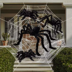 Hairy black Halloween spider props posed on a white web across a porch, with red eyes and posable legs
