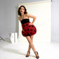 Model posing in a studio wearing a black halter bandeau dress with a red ladybug print tulip hem skirt