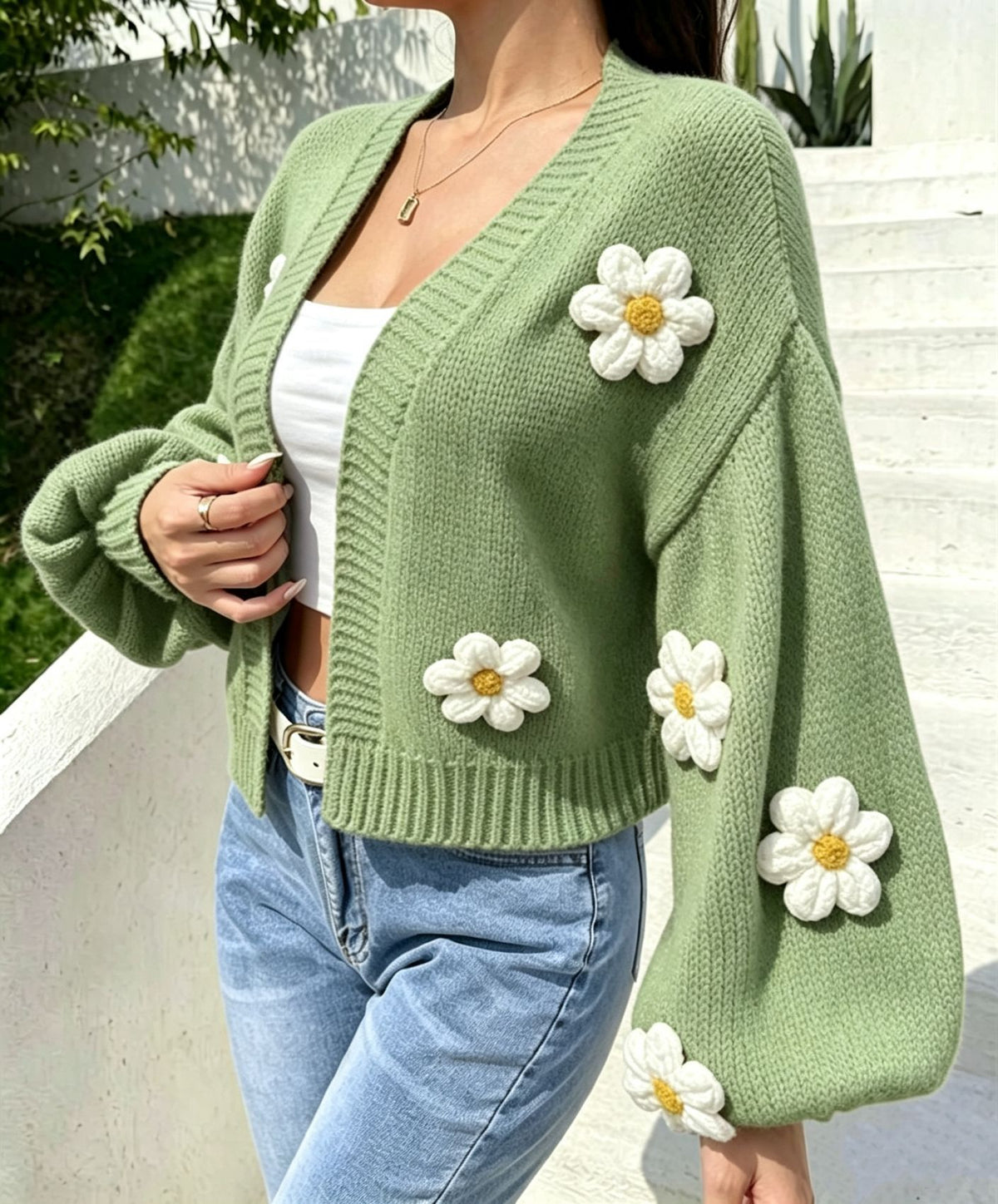Floral knit cardigan laid to show the open front and cropped hem