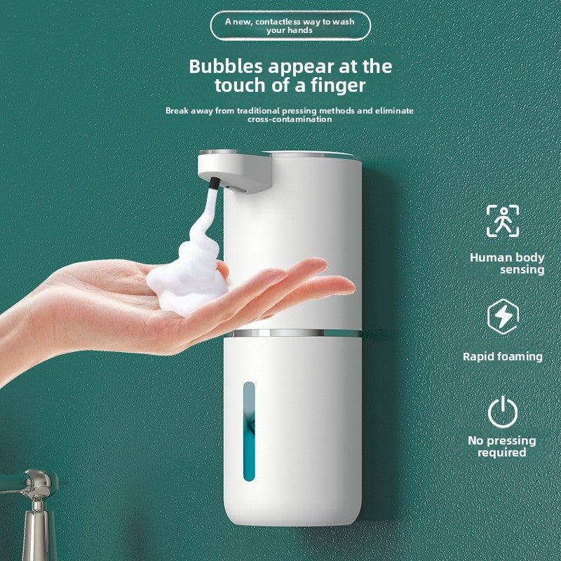 Hand under a white wall mounted soap dispenser receiving foam, icons for human body sensing, rapid foaming and no pressing