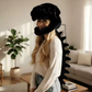 Black plush dinosaur skeleton head mask worn from the side with the trailing plush spine