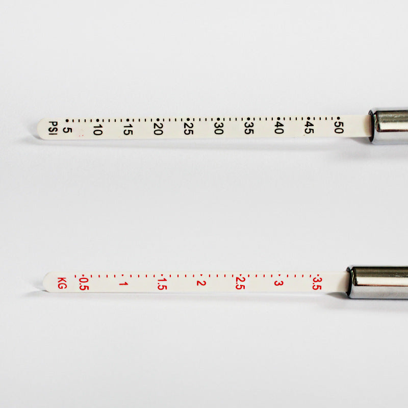 Close view of the two printed scale sticks, one graduated 5 to 50 PSI and one 0.5 to 3.5 kg