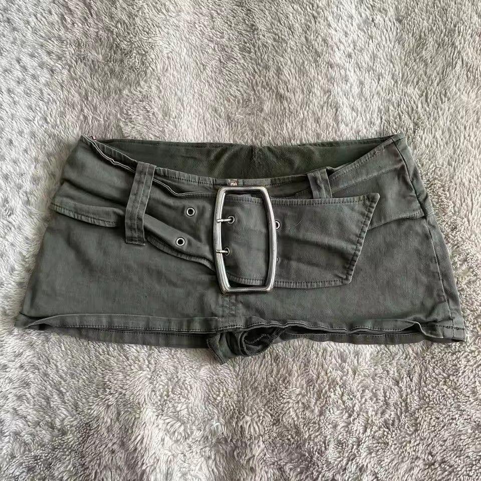 Olive green low rise mini skirt with large silver buckle belt flat lay