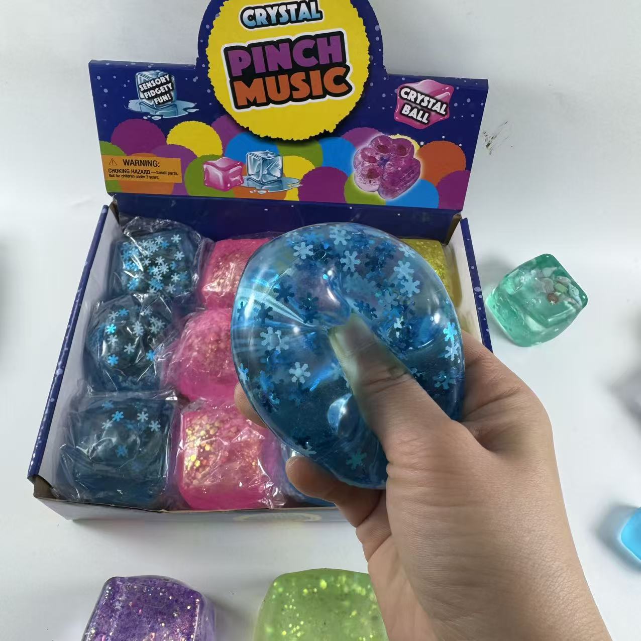 Small and large blue gel snowflake cube squishy toys shown together for size