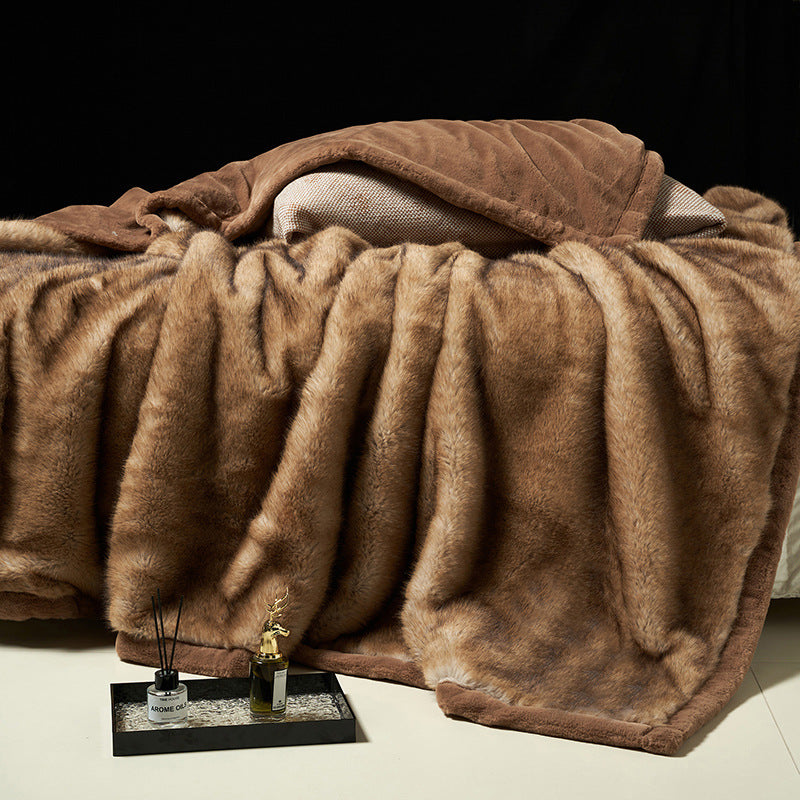 Camel vegan fur blanket draped over a bed with a smooth brown border, a diffuser and a tray at the foot