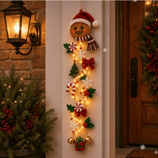 Gingerbread Christmas door hanger glowing on a porch pillar beside a lantern, Gingerbread option