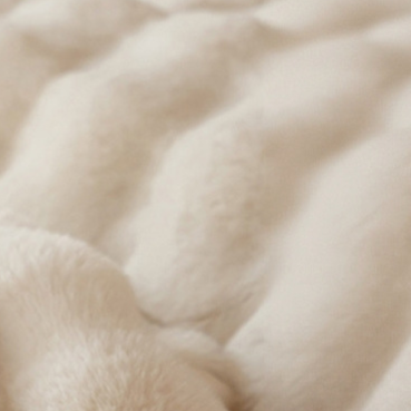 Close view of the ruched bubble texture on a plush polyester coral fleece throw