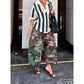 Green camouflage wide-leg pants worn with a green and white striped top, hands near the waistband, front view