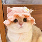 Pink flower hand crocheted pet hat worn by a fluffy cat