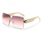 Champagne toned rimless shield sunglasses with a snake head ornament at the temple