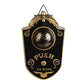 Black and gold Halloween eyeball doorbell prop hanging by its wire hook, glowing green eye and Push To Ring