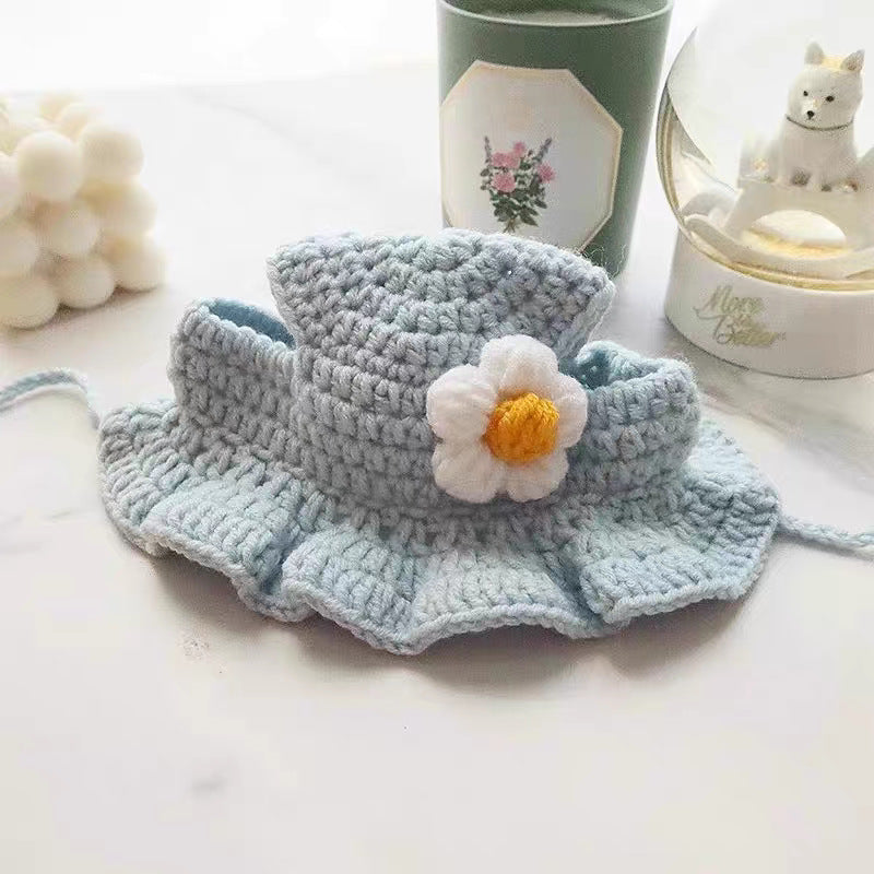 Blue flower hand crocheted pet hat with a ruffled brim, flat lay