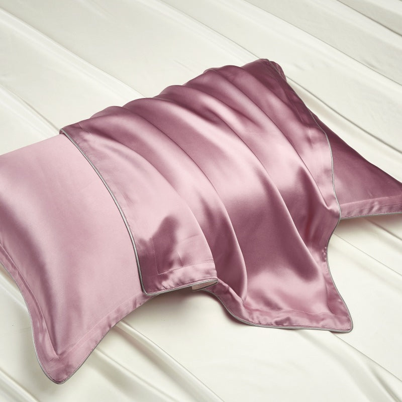 Champagne gold silk pillowcase catching the light on a pale bed